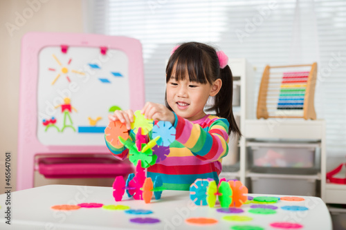 young girl playing creative toy blocks at home 