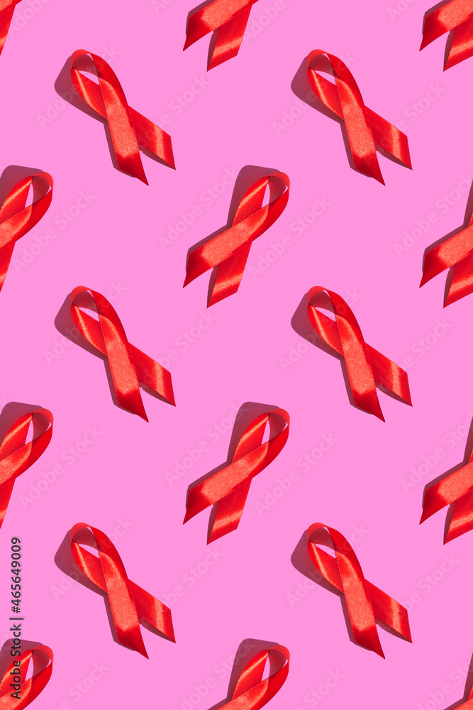 International AIDS Day. Red ribbon with a hard shadow on a pink background. AIDS awareness concept. Vertical. Pattern International AIDS Day. Red ribbon with a hard shadow on a pink background. AIDS awareness concept. Vertical. Pattern