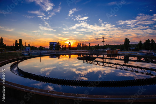 Modern sewage treatment plant. Round wastewater purification tank at sunset photo