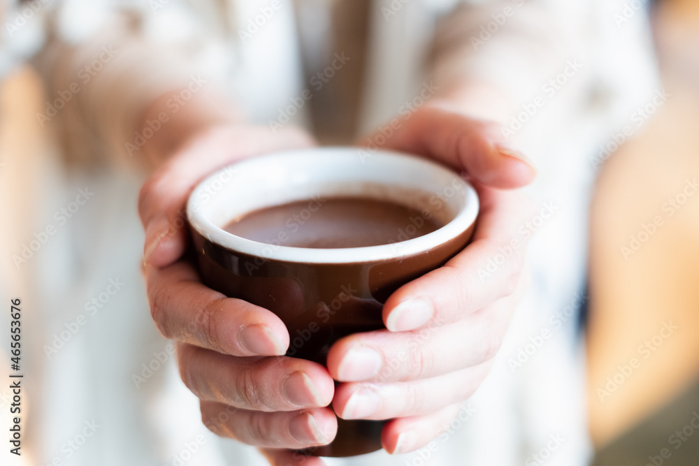 Cacao ceremony. Female hand holding a cup of pure shamanistic ceremonial cacao drink. Cacao ceremony. Female hand holding a cup of pure shamanistic ceremonial cacao drink.