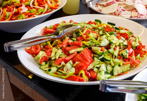 A mix of cucumbers and bell peppers is on a large plate.