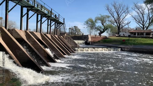 View of the outflow of water from the dam gates and cascade in San Antonio de Areco, Buenos Aires, Argentina. photo