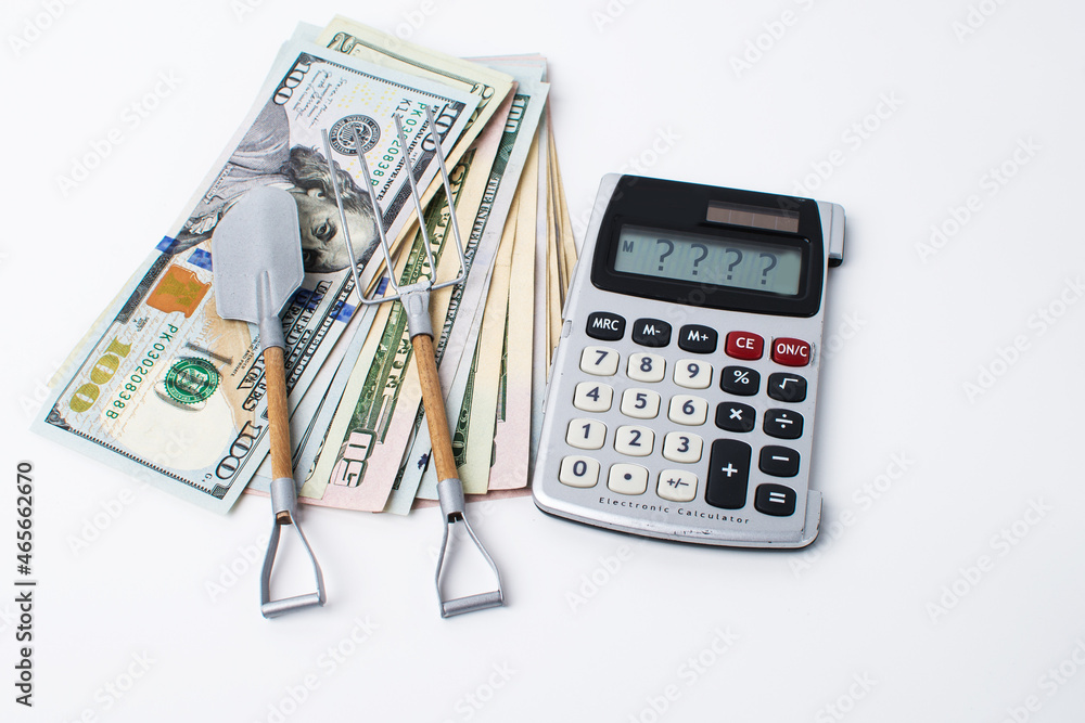 dollars, calculator and agricultural tools on a white background. dollars, calculator and agricultural tools on a white background.