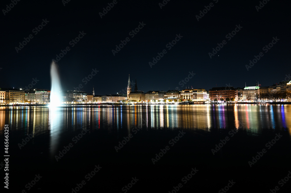 Fototapeta premium City of Hamburg at night. Panoramic view of Hamburg and Aussen-Alster lake, Germany. Buildings, towers and Alsterfontäne. 