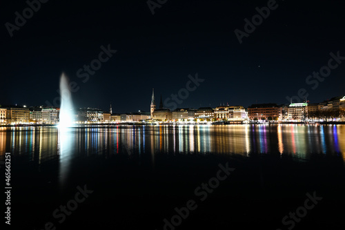 City of Hamburg at night. Panoramic view of Hamburg and Aussen-Alster lake, Germany. Buildings, towers and Alsterfontäne. 