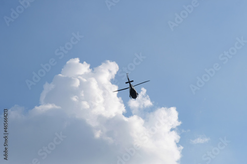 On the azure sky, a helicopter flies.