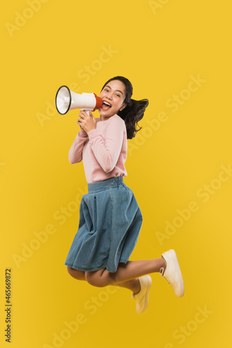 Принти на полотні A girl jumping and screaming using a megaphone on