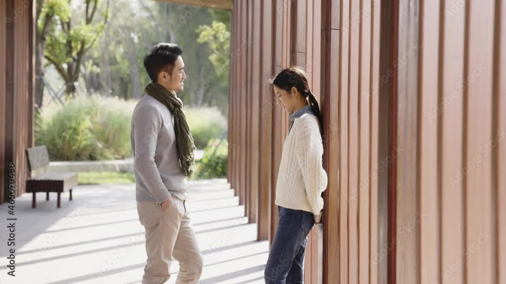 young asian couple conversing outdoors in city park young asian couple conversing outdoors in city park