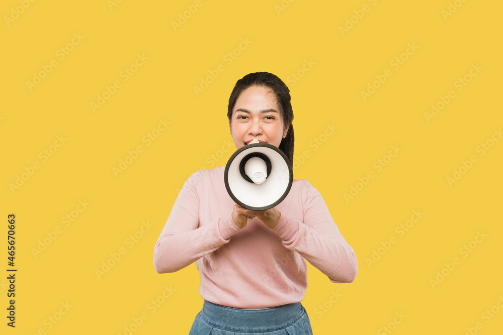 Asian woman screaming while holding megaphone with two hands making announcement Asian woman screaming while holding megaphone with two hands making announcement