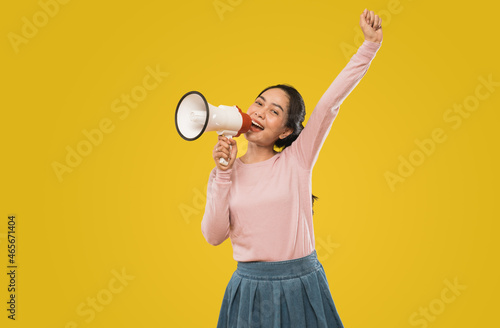 Cute girl shouting with opening mouth during making announcement using megaphone © Odua Images