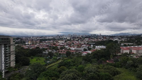 Cinematic drone shot flying towards San Jose city, Costa Rica. Aerial cityscape photo