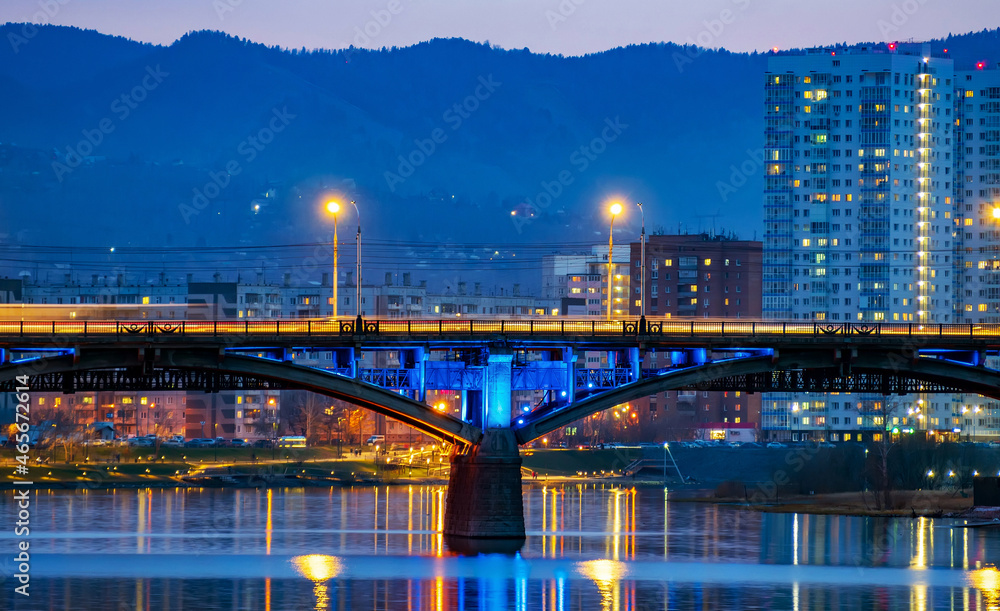 Reinforced concrete bridge across the river at the late evening. Cityscape.