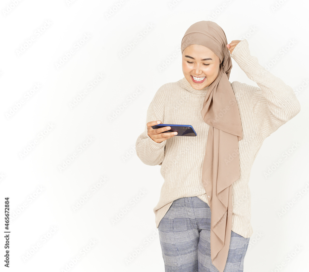 Playing game on smartphone of Beautiful Asian Woman Wearing Hijab Isolated On White Background Playing game on smartphone of Beautiful Asian Woman Wearing Hijab Isolated On White Background