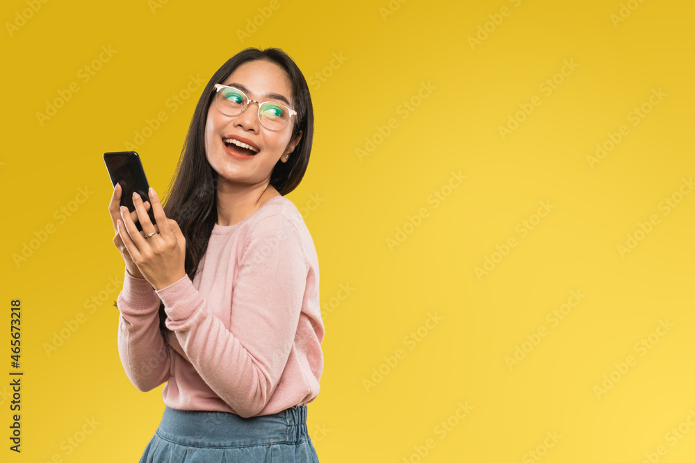 attractive woman in glasses smiling while using a mobile phone attractive woman in glasses smiling while using a mobile phone