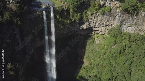 Aerial : Slowly pushing in towards Chamarel waterfall incredible sun lit water streams photo