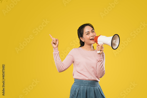 Asian girl with finger gesture pointing making announcement megaphone photo