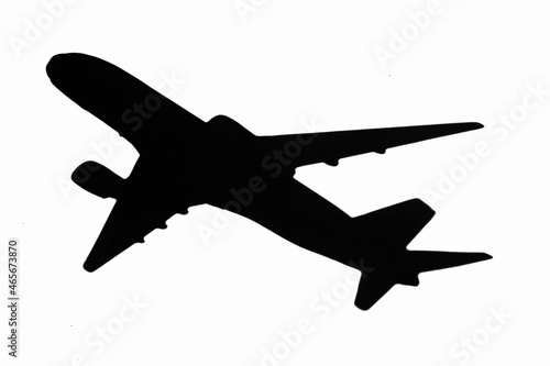 Black airplane silhouette flying off white background isolated.