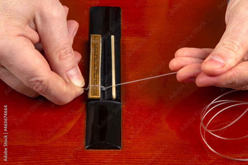 replacement and insertion of nylon strings in a classical guitar ...