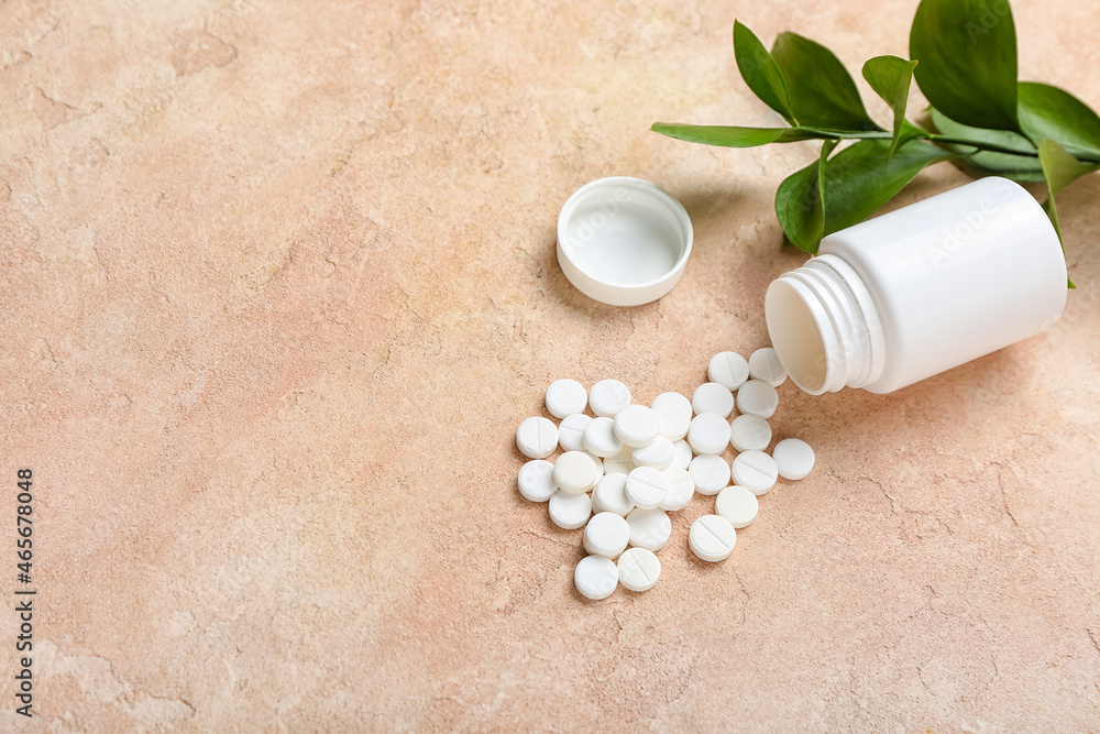 Bottle with pills and green branch on color background Bottle with pills and green branch on color background