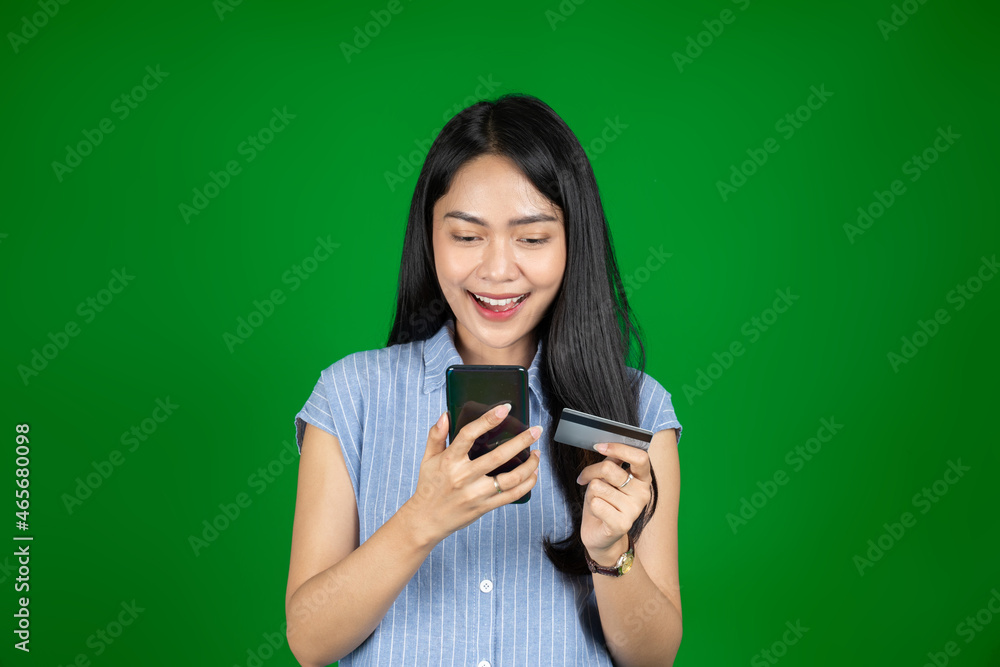 asian woman using mobile phone while holding atm card asian woman using mobile phone while holding atm card