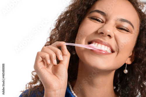African-American woman with chewing gum on white background