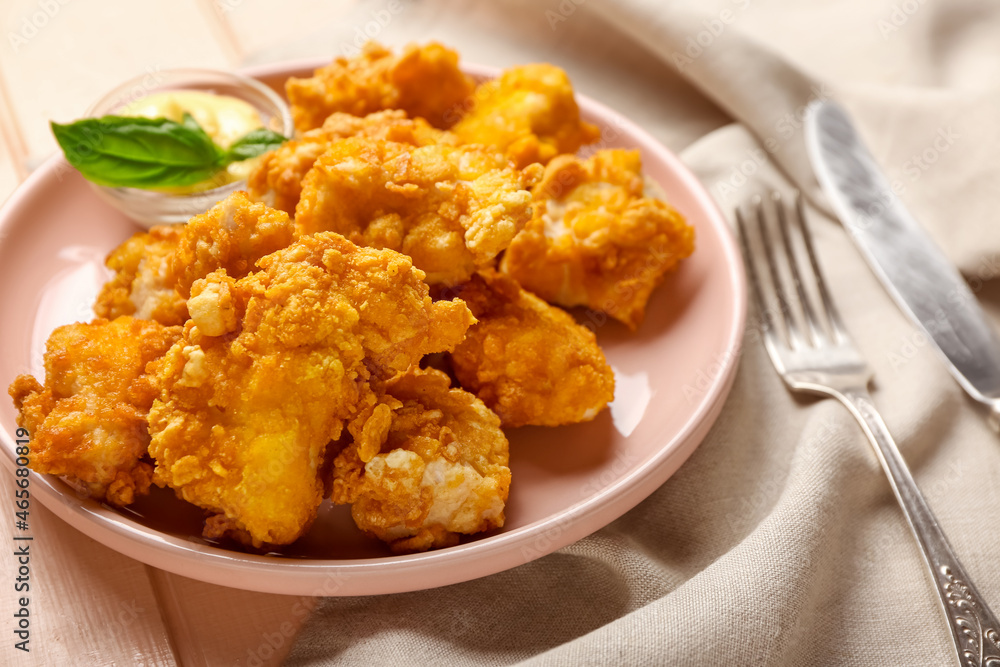 Plate with tasty popcorn chicken, basil and sauce on table, closeup Plate with tasty popcorn chicken, basil and sauce on table, closeup
