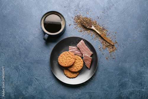 Plate with tasty hojicha cookies and cup of coffee on black background photo