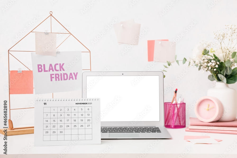 Calendar page of November 2021 and laptop on table. Black Friday Calendar page of November 2021 and laptop on table. Black Friday