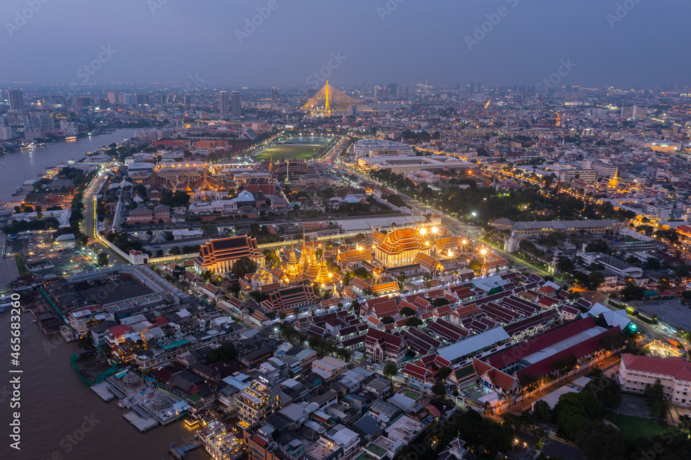 Aerial view Day to Night of Chao Phraya River with Royal Grand Palace and Emerald Buddha Temple Landmark of Bangkok, Thailand. Amazing Drone Footage over the City skyline in twilight.