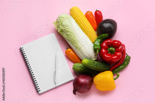 Blank notebook  pen and vegetables on color background. Vegan Day