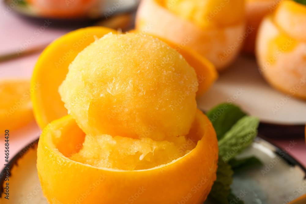 Plates with tasty ice creams in orange peels on color background Plates with tasty ice creams in orange peels on color background
