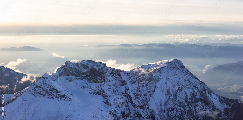 Obraz premium Aerial View of Canadian Rocky Mountains with snow on top during Fall Season Sunset. Nature Landscape located near Chilliwack, East of Vancouver, BC, Canada.