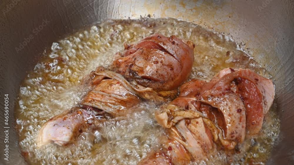 Two pieces of Chicken Drumstick sizzling in a hot deep oil in a frying pan. Two pieces of Chicken Drumstick sizzling in a hot deep oil in a frying pan.