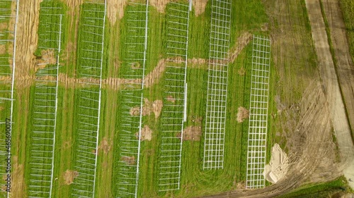 photovoltaic farm construction site, green field prepared for solar power plant construction - aerial top down photo