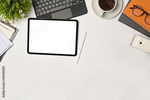 Mock up digital tablet with empty display, stylus pen and coffee cup on white table.