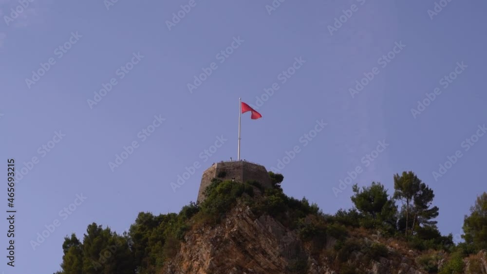 Beautiful Albanian flag slowly waving on top of stone pillar of Berat Castle Beautiful Albanian flag slowly waving on top of stone pillar of Berat Castle