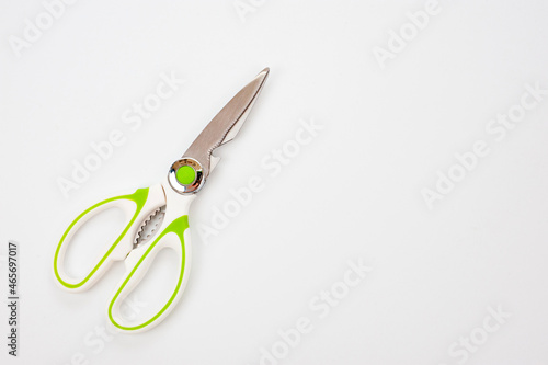 Metal scissors, universal with a white plastic handle with light green rubberized inserts.