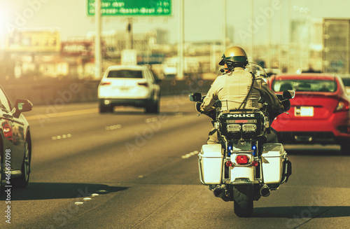 Caucasian Police Officer on a Motorcycle on a Highway