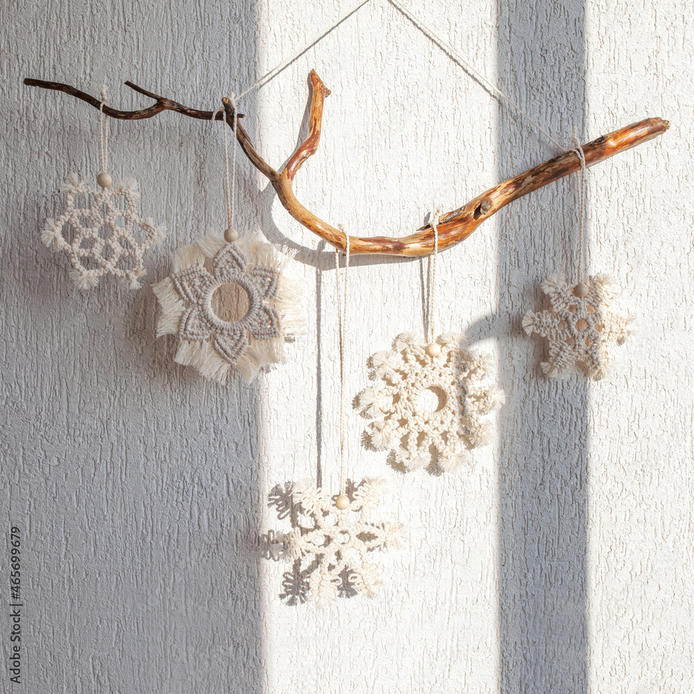 Christmas decor for home and cafe. Macram snowflakes hang on a wooden forest stick. Winter and New Year holidays. Christmas decor for home and cafe. Macram snowflakes hang on a wooden forest stick. Winter and New Year holidays.