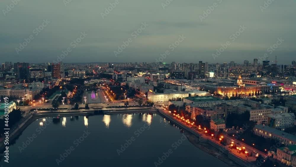 The central embankment of a large metropolis at night. This is a dam near the Iset River in the city of Yekaterinburg, the capital of the Urals. The light of the lanterns is reflected in the water The central embankment of a large metropolis at night. This is a dam near the Iset River in the city of Yekaterinburg, the capital of the Urals. The light of the lanterns is reflected in the water