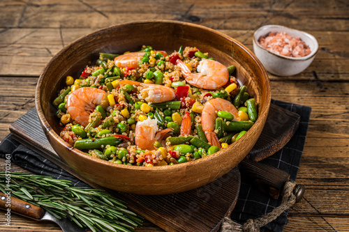 Diet menu, Vegan food. Healthy salad with quinoa, vegetables and Shrimps Prawns. Wooden background. Top view