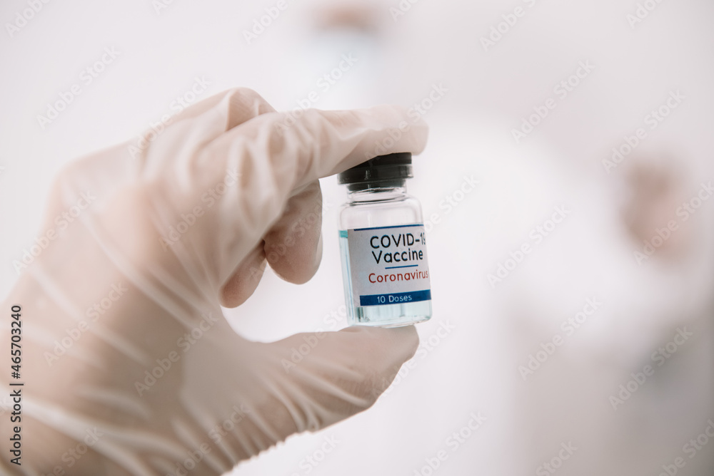 Doctor Hands in protective gloves holding Coronavirus 2019-nCoV Vaccine vial. Doctor Hands in protective gloves holding Coronavirus 2019-nCoV Vaccine vial.