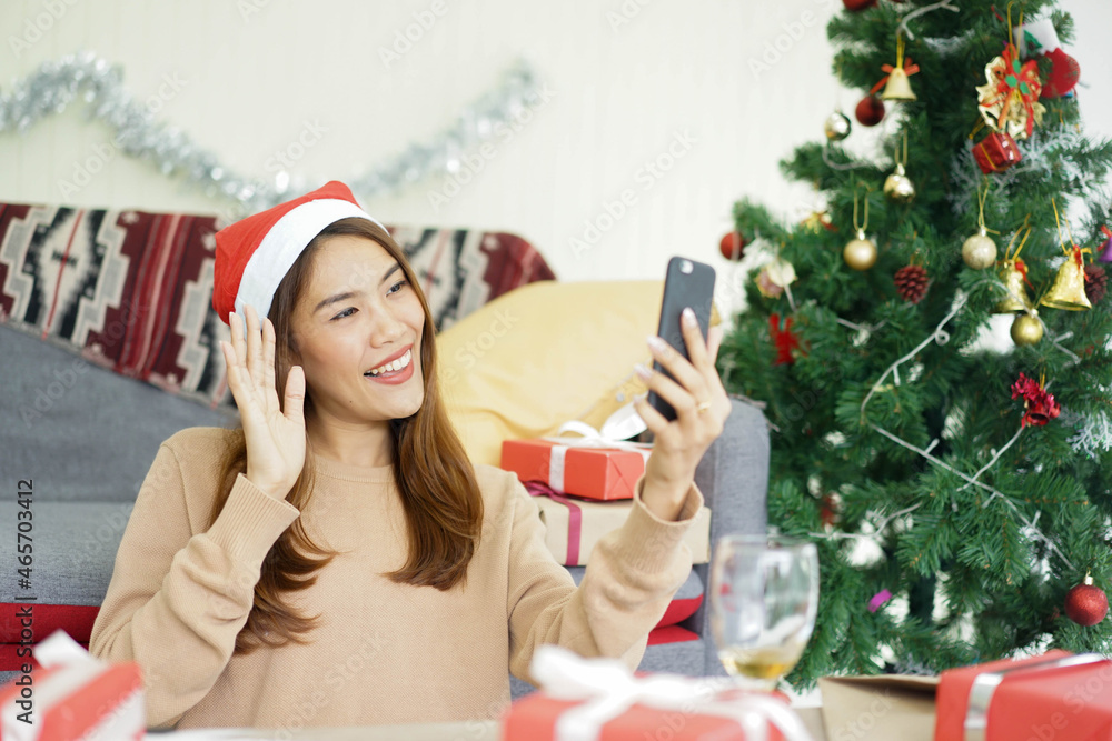 close up asian woman video call to talking and greeting with friends and family in ornamental living room at home for christmas celebration and people technology concept close up asian woman video call to talking and greeting with friends and family in ornamental living room at home for christmas celebration and people technology concept