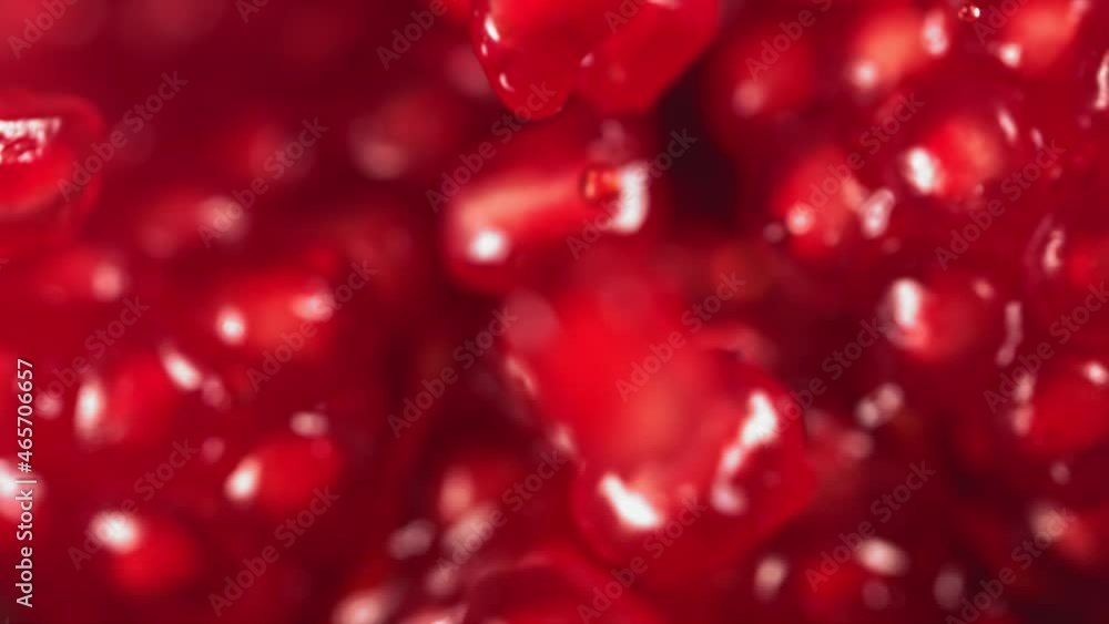 Pomegranate Grains rolls down on surface of broken pomegranate in slow motion Pomegranate Grains rolls down on surface of broken pomegranate in slow motion