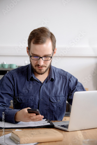 Man using laptop while sitting at wooden table
