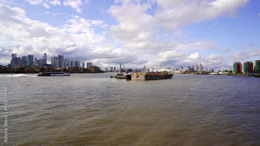 East London, wide view of the river Thames looking toward the modern skyline of Docklands and Canary Wharf with Greenwich and the Milleniem Dome on the other side of the river East London, wide view of the river Thames looking toward the modern skyline of Docklands and Canary Wharf with Greenwich and the Milleniem Dome on the other side of the river