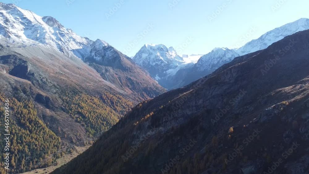 Drone flight over a lush green valley with snow-capped mountains in switzerland in valais Drone flight over a lush green valley with snow-capped mountains in switzerland in valais