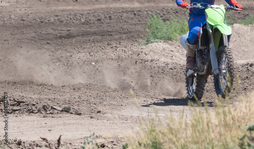 Motocross motor bike driving on race track and throwing up pieces of dirt with the tires