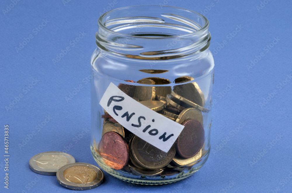 Concept de petite pension avec quelques pièces de monnaie dans un bocal en verre transparent sur fond bleu Concept de petite pension avec quelques pièces de monnaie dans un bocal en verre transparent sur fond bleu