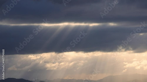 ダークなイメージの雲の流れと太陽の光芒